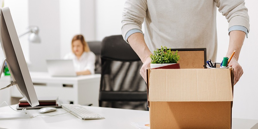 muž v kancelárii drží krabicu a je na odchode z práce